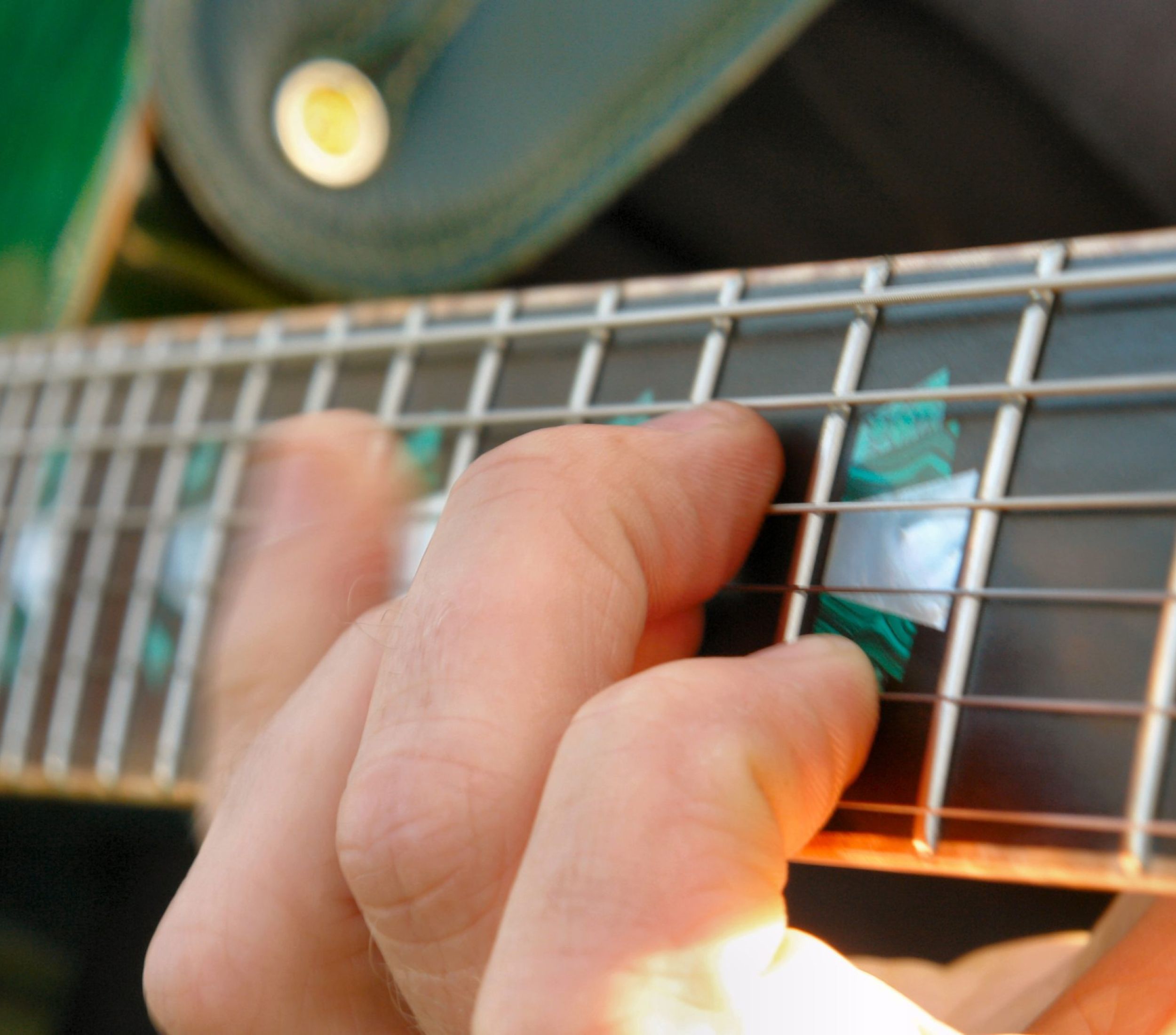 Fingers strumming a guitar.